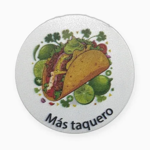 Pin impreso redondo a todo color con la ilustración de un taco y la frase Más taquero